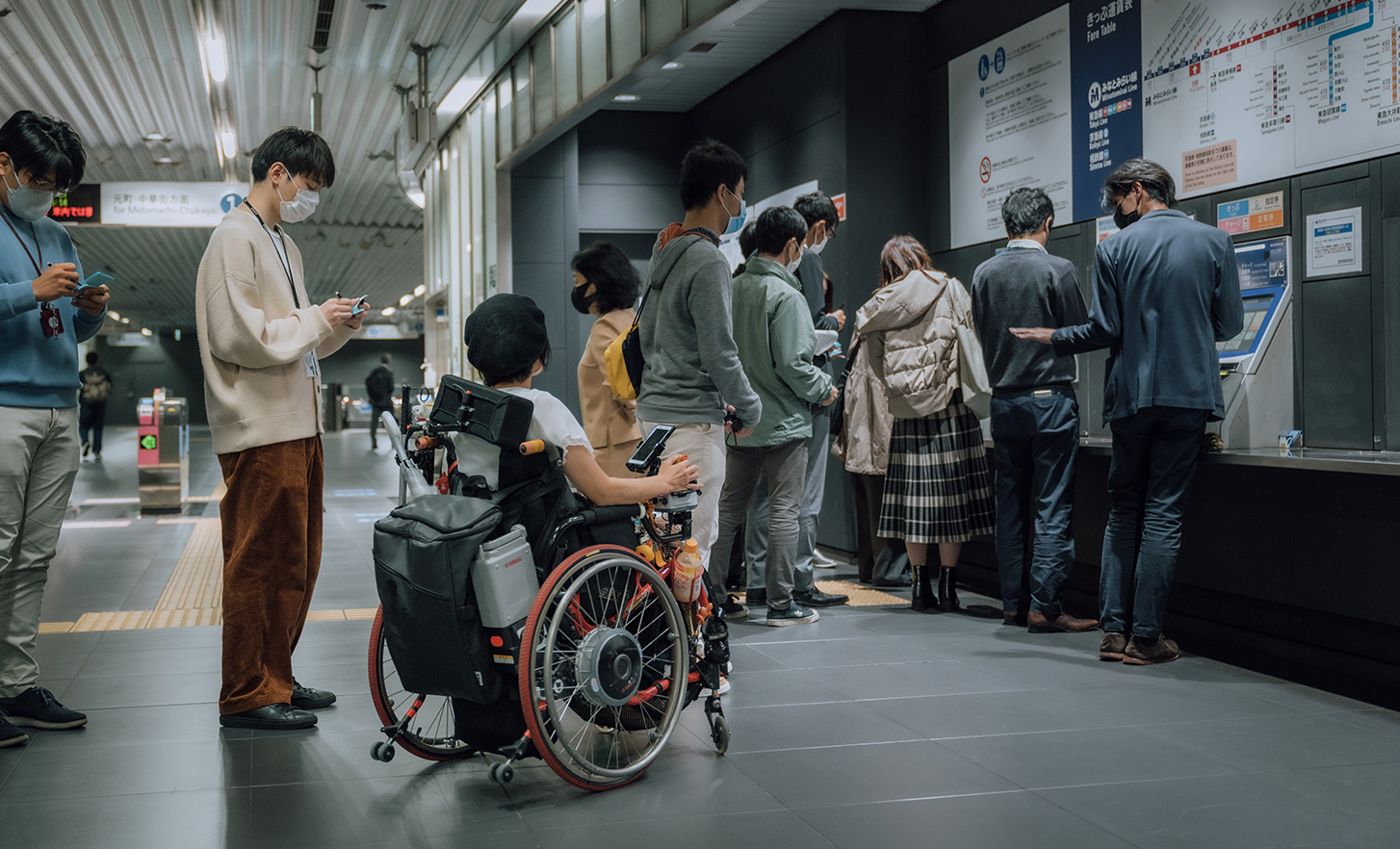 The lead user is buying a ticket at a ticket vending machine