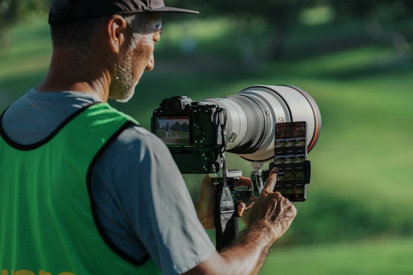 Usage image of a man operating his smartphone while shooting with the camera