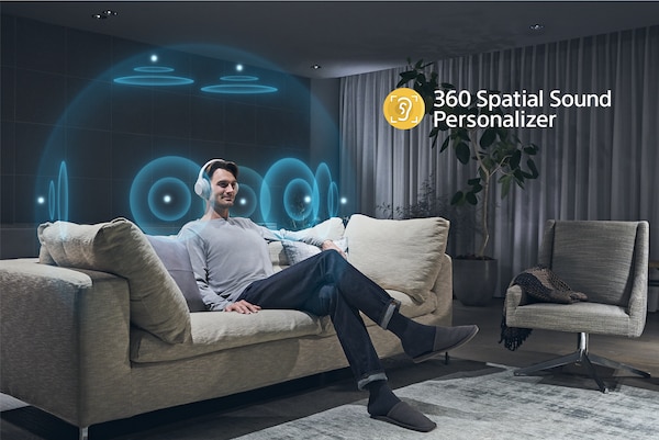 Man on a couch listening to headphones with an illustration of 360 Spatial Sound Personalizer effect around his head