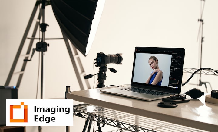 Image of studio illustrating Imaging Edge PC application, with camera on tripod, and PC with camera image on screen